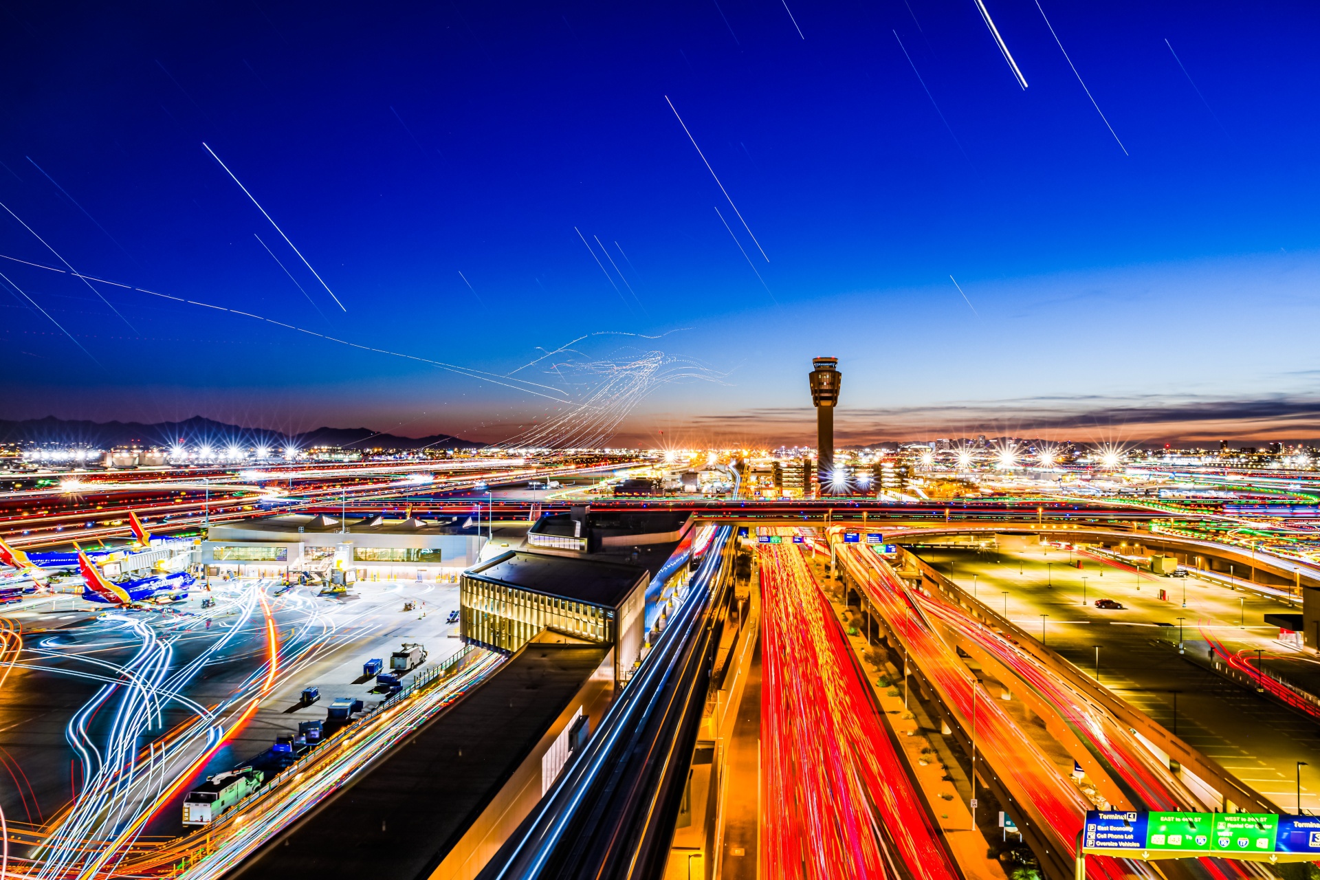 A nighttime photo of an airport with a green sign that says "green light".